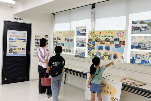 セミナー開催日の様子。オフィス・エフの会場の壁に貼られた「小学生ぼうさい探検隊マップ」を子どもと保護者が眺めている。