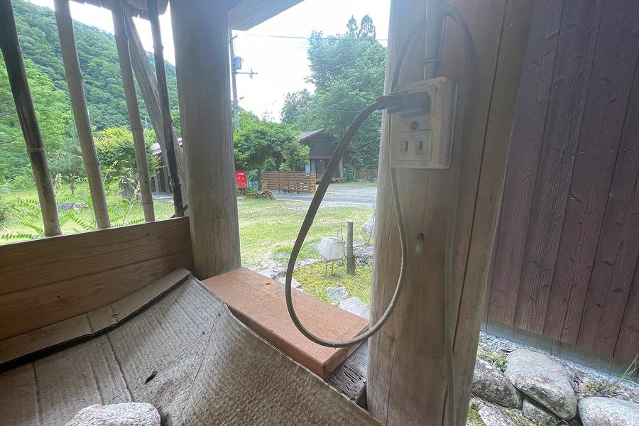 共同水場の中にあるコンセントの画像。２つ口があり、上の口には何かの電源のプラグが差し込まれている。