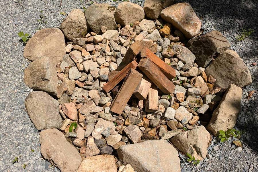 区画に完備されている焚火場に薪が置かれている。